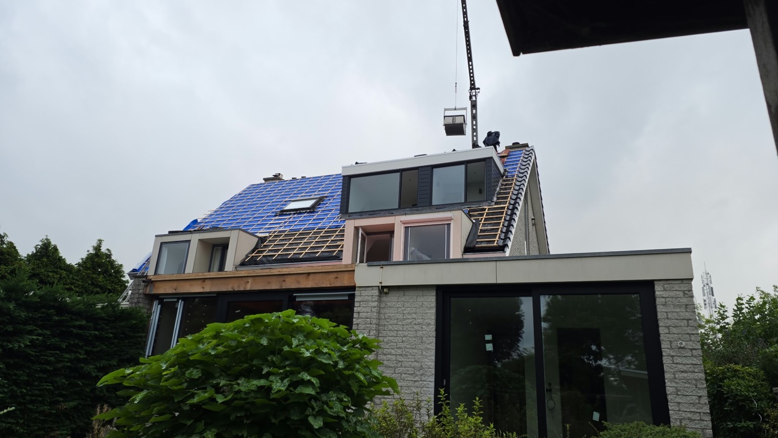Kraan van De Mannen van de Pannen in actie bij een dakklus